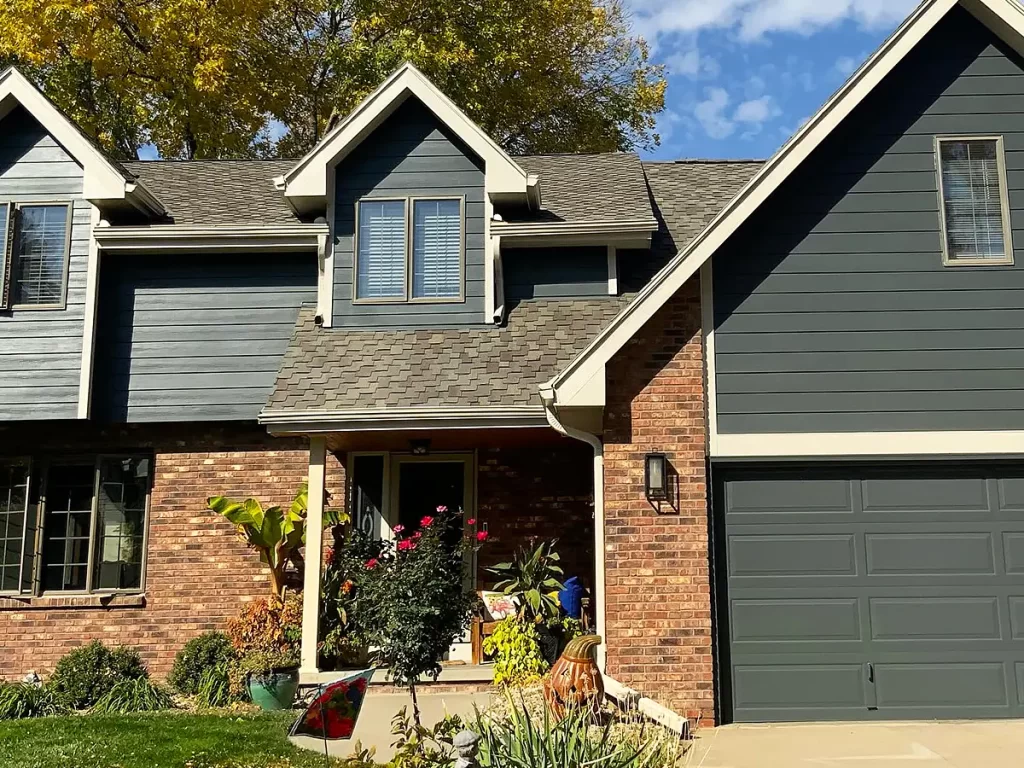 Two-story home with a mix of brick and dark siding, showcasing a durable and modern exterior.