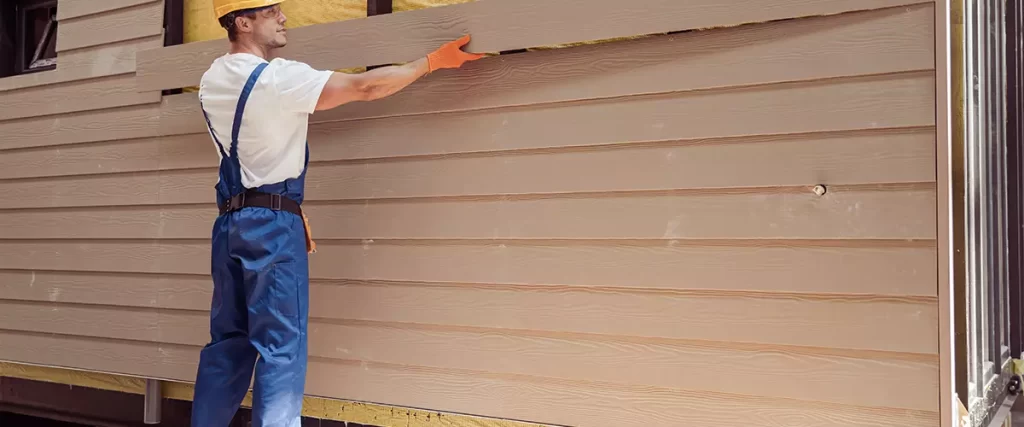 A worker installing James hardie cobblestone siding