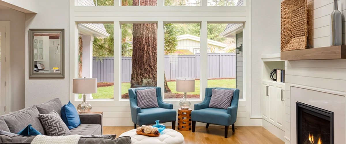window replacement omaha ne window installation spacious living room with large windows gray sofa blue armchairs fireplace