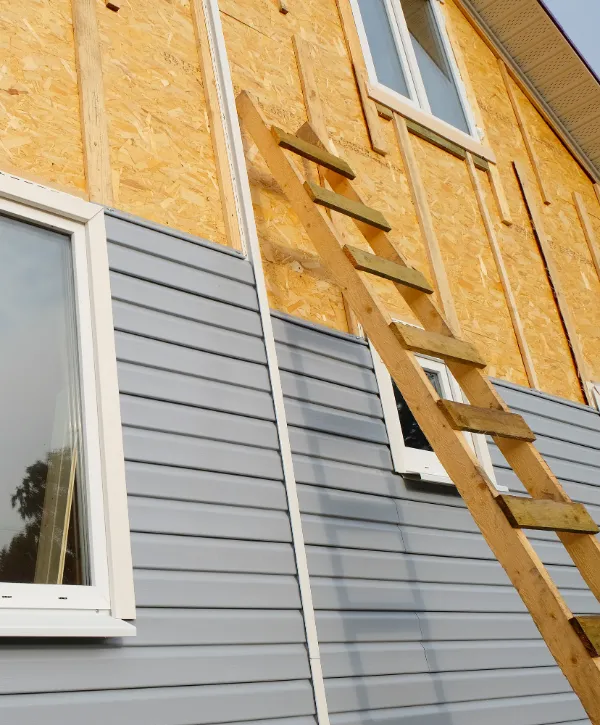a house exterior undergoing vinyl siding installation