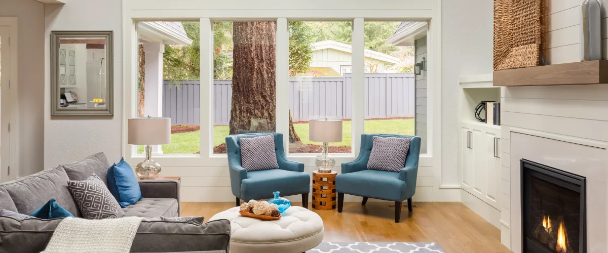 a living room featuring large windows that offer a bright view of a fenced backyard.