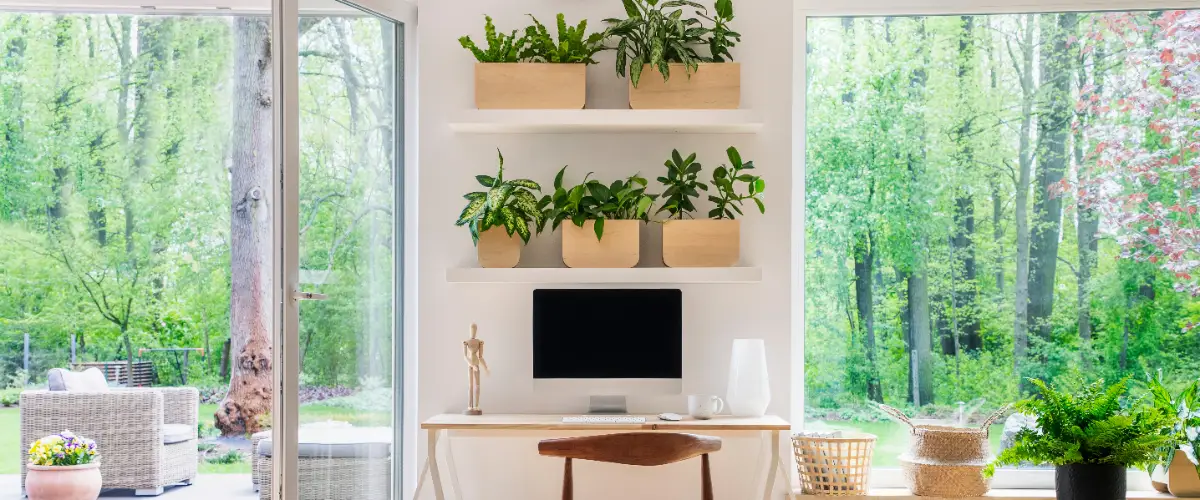 a room featuring floor-to-ceiling windows and sliding glass doors that open onto a lush green outdoor area