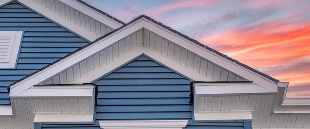 siding blue vinyl siding with white trim accents and sunset sky backdrop