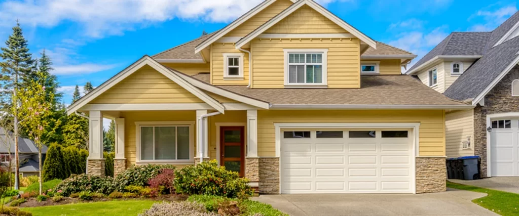 siding yellow house with professional siding stone accents and landscaped front yard