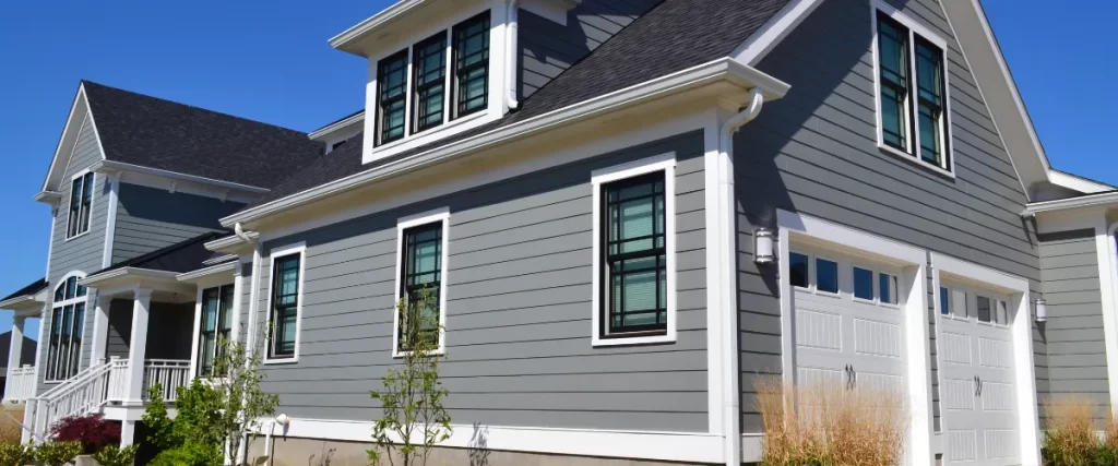 a house with horizontal siding with white trim around the windows and roofline