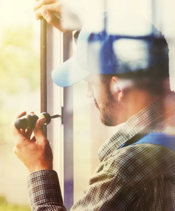 a worker working on a window using a screwdriver during window replacement
