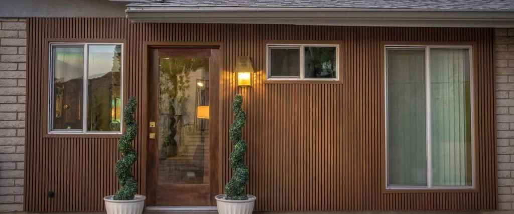 Detailed view of durable dark grey panel siding with clean lines installed on the side of a modern house.