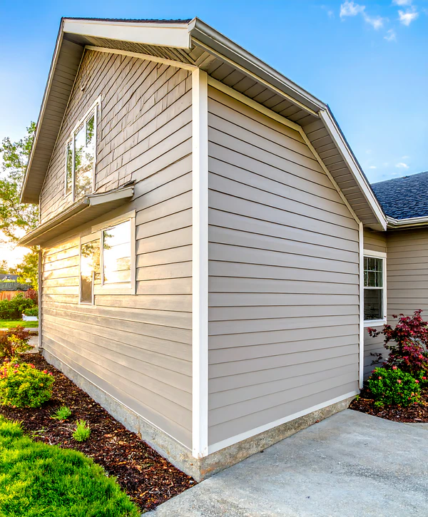A residential house featuring newly installed tan horizontal vinyl siding by professional siding installation companies in North Omaha, NE.