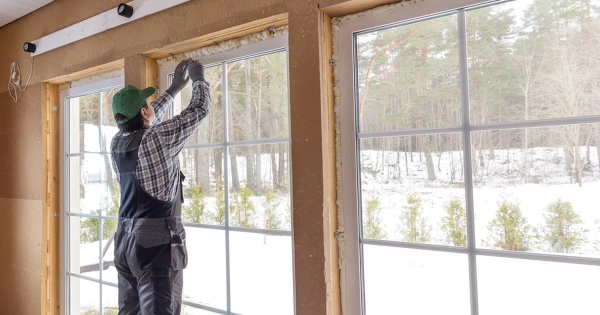professional contractor installing large glass windows with precision in snowy setting