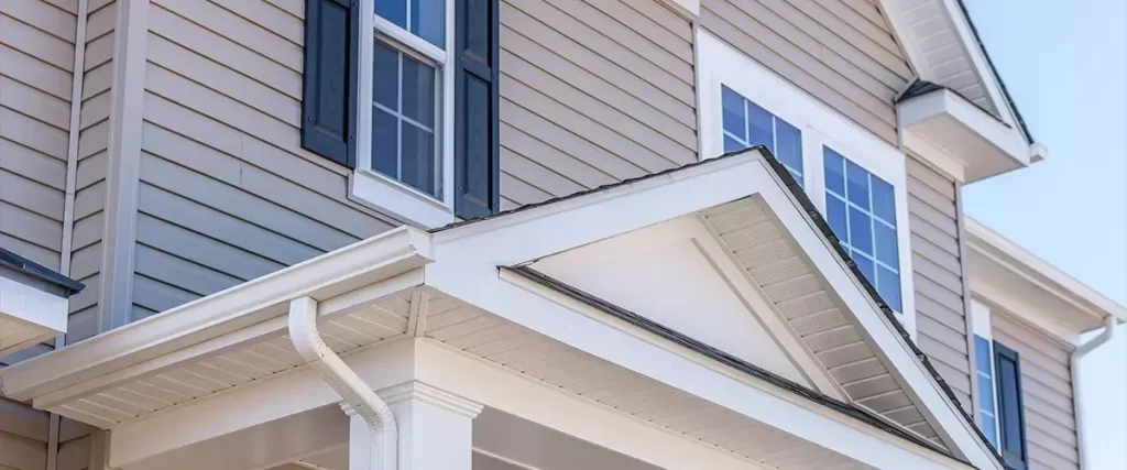 Vinyl siding soffit and gutter installation on a residential home entryway and roof overhang